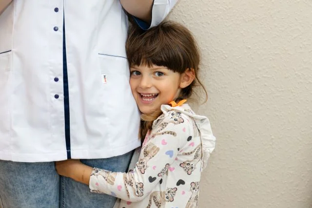 EQ Smile - Zahnarztpraxis -  kleines Mädchen umarmt